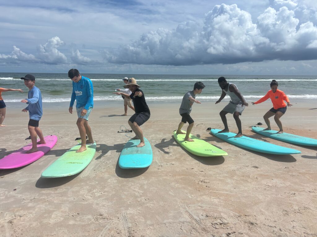 Alunos Latitude Language aprendendo a surfar na praia